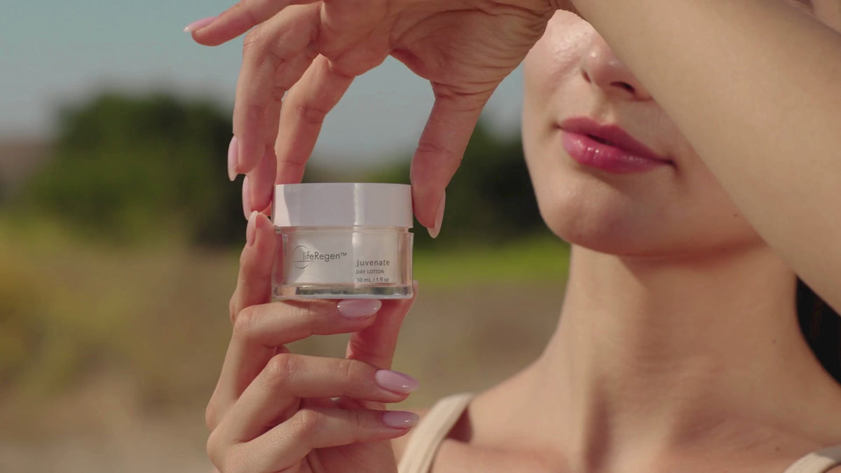 Hands holding a jar of lifeRegen Juvenate Day Lotion outdoors